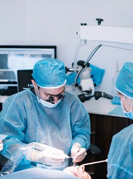 a dental implant dentist performing placement surgery