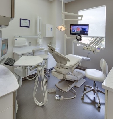 Dental treatment room with white leather exam chair