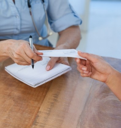 Person handing a paper check to someone across a table