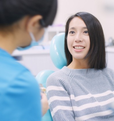 Woman in dental chair listening to her dentist talk