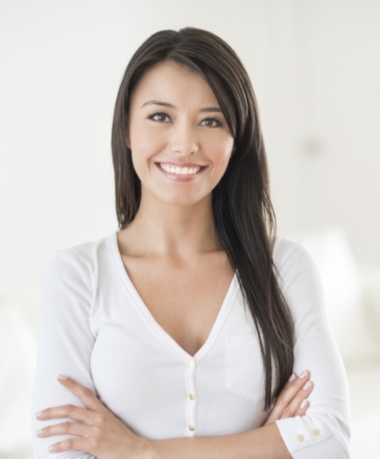 Brunette woman in white blouse smiling after cosmetic dentistry in San Jose