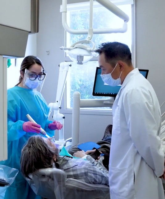 Dentist and assistant performing dental services in San Jose on a patient