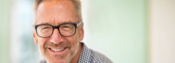 Smiling man in glasses and plaid shirt