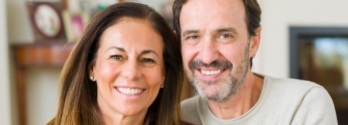 Man and woman smiling together in living room