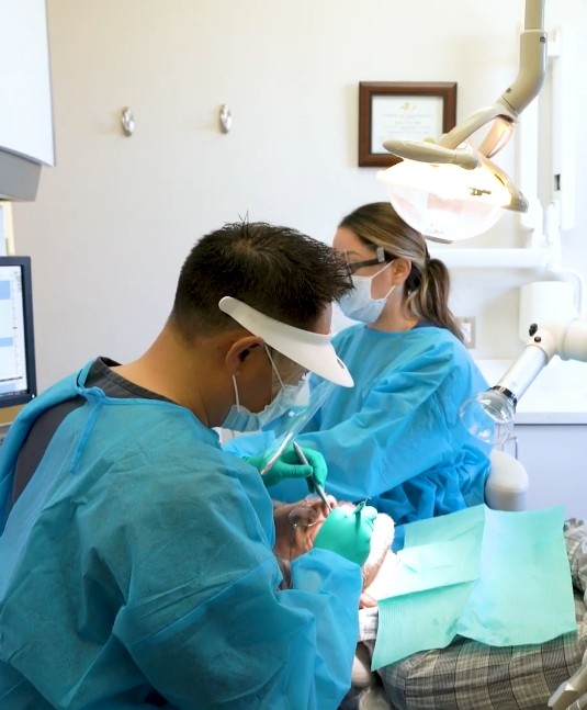 Dentist and assistant treating a patient using advanced dental technology in San Jose