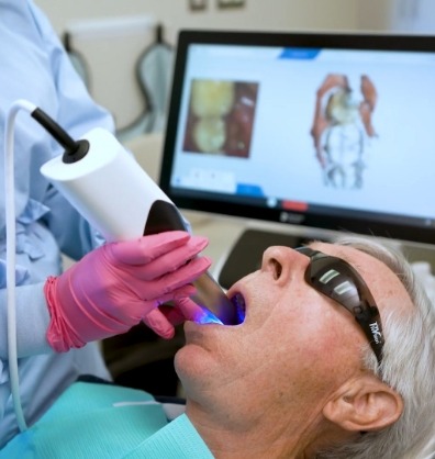 Senior dental patient having digital impressions taken of his teeth