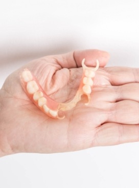 Hand holding a partial denture