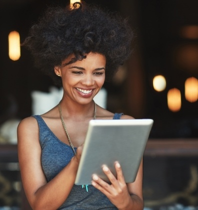 Woman smiling while scrolling on a tablet