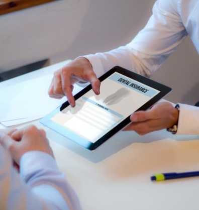 Two people looking at dental insurance information on a tablet