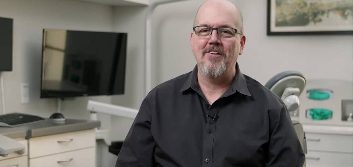 Man in black button down shirt sitting in dental office