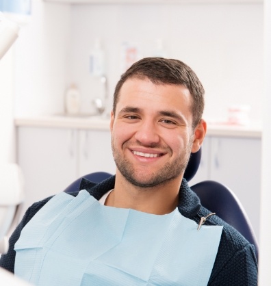 Young man smiling and sitting in dental chair