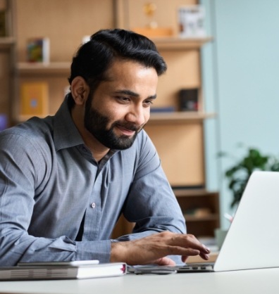 Man smiling while using laptop