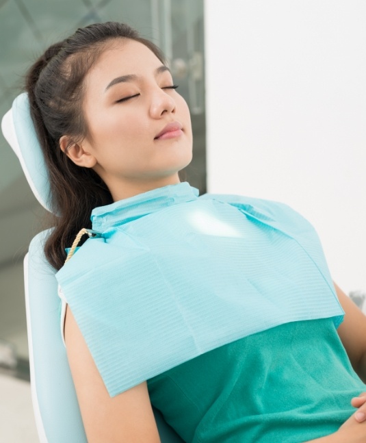 Woman relaxing in dental chair thanks to sedation dentistry in San Jose