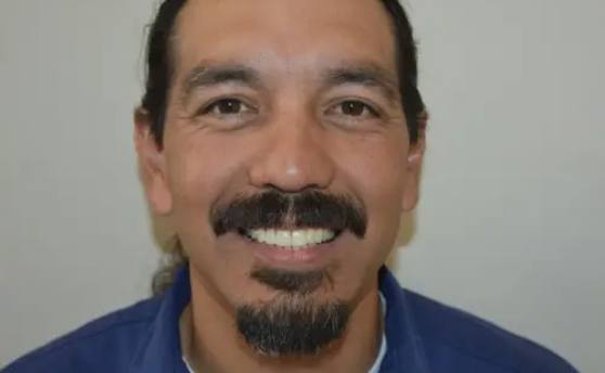 man with mustache and goatee smiling with flawless white teeth