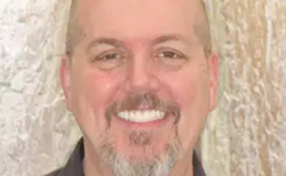 Man with gray goatee smiling with newly restored teeth