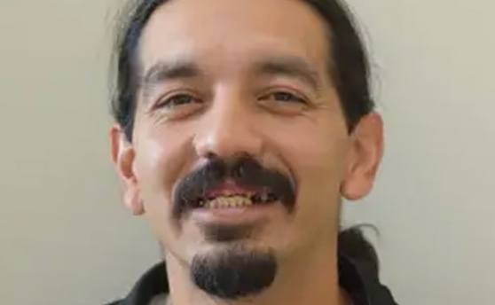 Man with mustache and goatee smiling with damaged teeth